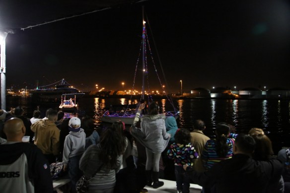 Onshore onlookers watch the 2014 holiday boat parade in San Pedro. (Daily Breeze staff file photo by Chuck Bennett)