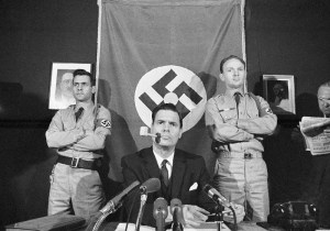 George Lincoln Rockwell, leader of the American Nazi Party holds a news conference in Arlington, Virginia, Nov. 3, 1965. At left is Matt Koehl, and at right is Alan Welch, deputy commander. (AP Photo/Harvey Georges)