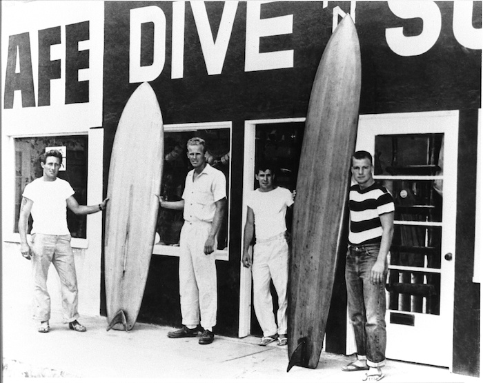 L to R: Dale Velzy, Hap Jacobs, Bill Meistrell and Bev Morgan at the original Dive N Surf Shop in 1954. (Photo credit: Encyclopedia of Surfing.)