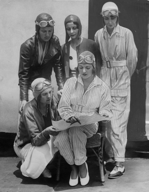 Famous women pilots preparing to take part in the 1934 Memorial Day air races at Dycer Airport. In front row kneeling is Gladys O’Donnell. Seated is Ruth Elder, famous flying beauty. Standing left to right: Kay Van Doozer, Myrtle D. Mims and Clema Granger