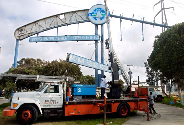 Workers remove the Redondo Beach King Harbor gateway sign on May 19, 2004 in preparation for replacing it with a replica sign. Daily Breeze file photo by Scott Varley.