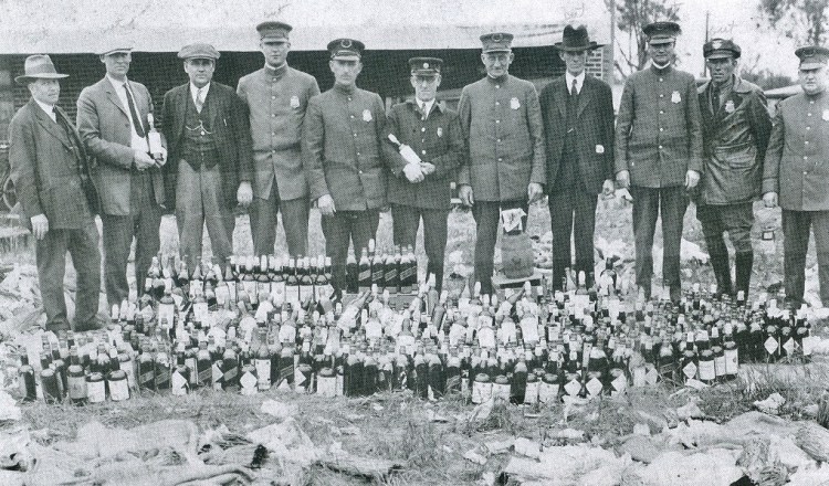 Torrance police officers pose with seized illegal liquor in this 1925 photo. (Torrance Police Department photo)
