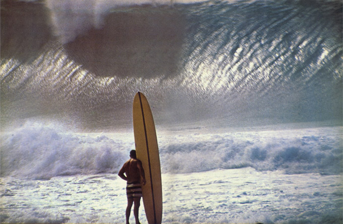 Greg Noll eyes massive waves at Waimea Bay in 1957 in this iconic surfing photo. (Photo by John Severson)