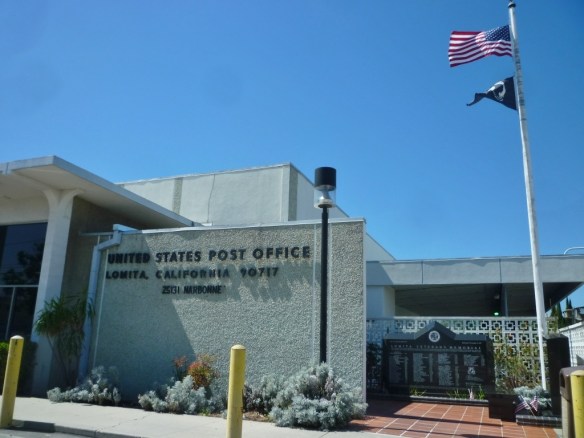 The POW/MIA flag flies at the U.S. Post Office in Lomita, right, on Sept. 18, 2015, National POW/MIA Recognition Day. The Lomita Veterans Memorial is visible at lower right. (Daily Breeze photo)