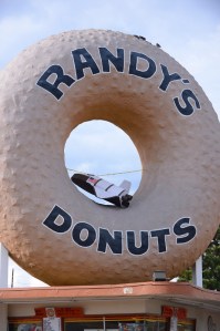A large model of a space shuttle appears to fly through the hole in Randy's Donuts landmark sign along Manchester Blvd. on the eve of the Endeavour's slow roll to the California Science Center fro LAX. Daily Breeze file photo by Brad Graverson, Oct. 10, 2012.