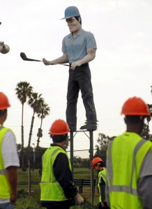 Workers cleaning the landscaping along the southbound San Diego 405 Freeway in Carson are dwarfed by the iconic Golf Man statue at the Dominquez Hills Golf Course. (Daily Breeze file photo by Sean Hiller, March 11, 2009.)