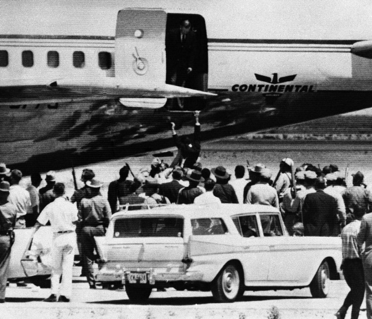 An unidentified passenger jumps into the arms of waiting police officers from a hijacked aircraft held by gunmen at El Paso, Texas on August 3, 1961. The gunmen, a father and son, held the crew and several passengers hostage for several hours before they were taken into custody. (AP Photo)