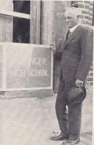 Adolph Leuzinger stands next to the cornerstone which bears his name at Leuzinger High School, October 3, 1929. 