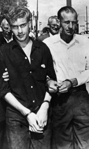 Leon Bearden, right, and his 17-year-old son Cody are handcuffed as they are taken from the federal building in El Paso, Texas on August 3, 1961, to the county jail after they had been charged with hijacking an airliner. They held the crew and passengers hostage for several hours before they surrendered the plane at El Paso. The pair said they wanted to take the plane to Cuba. (AP Photo)