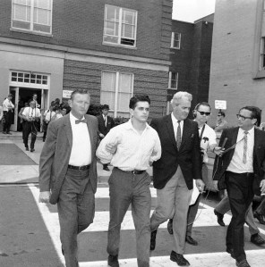 John Patler, 29, of Arlington, Va., is lead by police outside Arlington police headquarters on August 25, 1967 following his arrest. Patler, former captain in George Lincoln Rockwell’s American Nazi Party, is charged with killing his former commander. (AP Photo)
