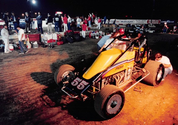 A pit crew works on a sprint car in the pits at Ascot Park in August 1990. (Daily Breeze staff file photo)