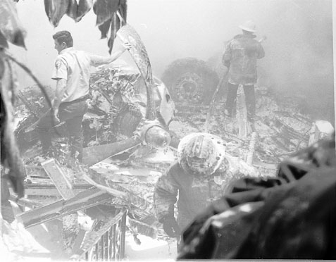 Firefighters make their way through the wreckage following the B-26 crash in El Segundo. The man at left braces himself on on of the downed aircraft's engine propellers. Daily Breeze file photo.