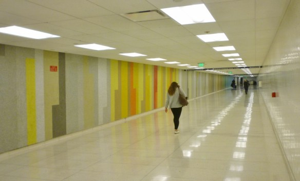 Second half of mosaic on the wall of the Terminal 6 passenger walkway at LAX. The lone red portion can be seen just to the left of the woman walking. (November 2016 Daily Breeze photo)