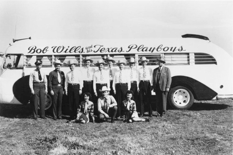 Bob Wills and His Texas Playboys pose in front of their tour bus in this undated photo. (Credit: Wikimedia)