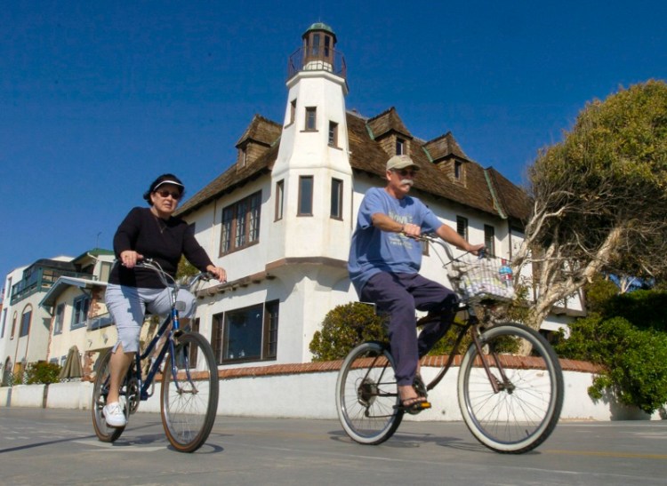 Bicyclists pass by the "lighthouse" house in Hermosa Beach. The home at 100 The Strand was part of a struggle between the property owner and historic preservationists. Jan. 28, 2004 file photo. (Brad Graverson / Staff Photographer)