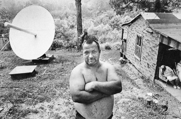 Bert Jett proudly stands in the yard of his home near Blue Creek, where he and his two brothers have installed a $7,800 satellite receiving dish so they can get better TV reception in Elkview, W.Va., July 14,1981. The Jetts said they now can get nearly 60 stations around the globe and have their choice of four separate movie channels, as well as several Christian networks and most of the big city TV stations in this country. (AP Photo)